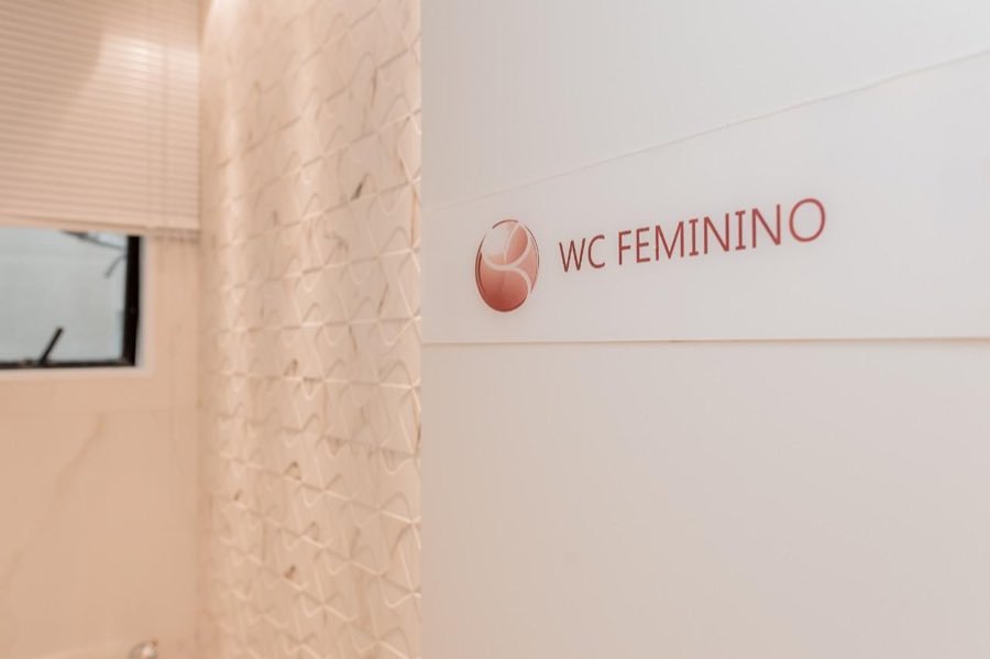 Porta do banheiro feminino com a placa da clínica