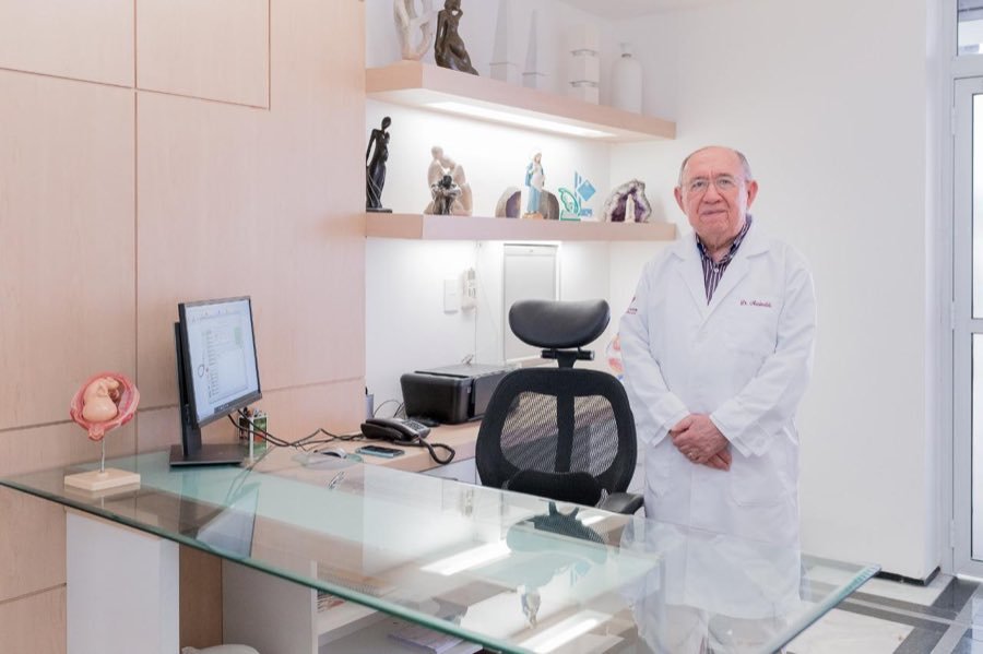 Dr. Marinaldo Cavalcanti e Melo em pé no seu consultório
