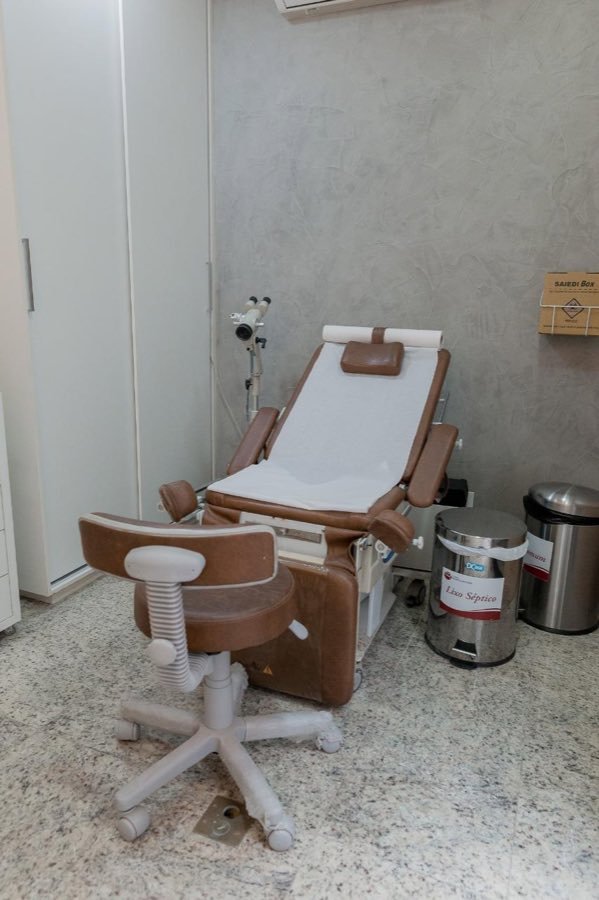 Cadeira ginecológica e banqueta em sala de exame