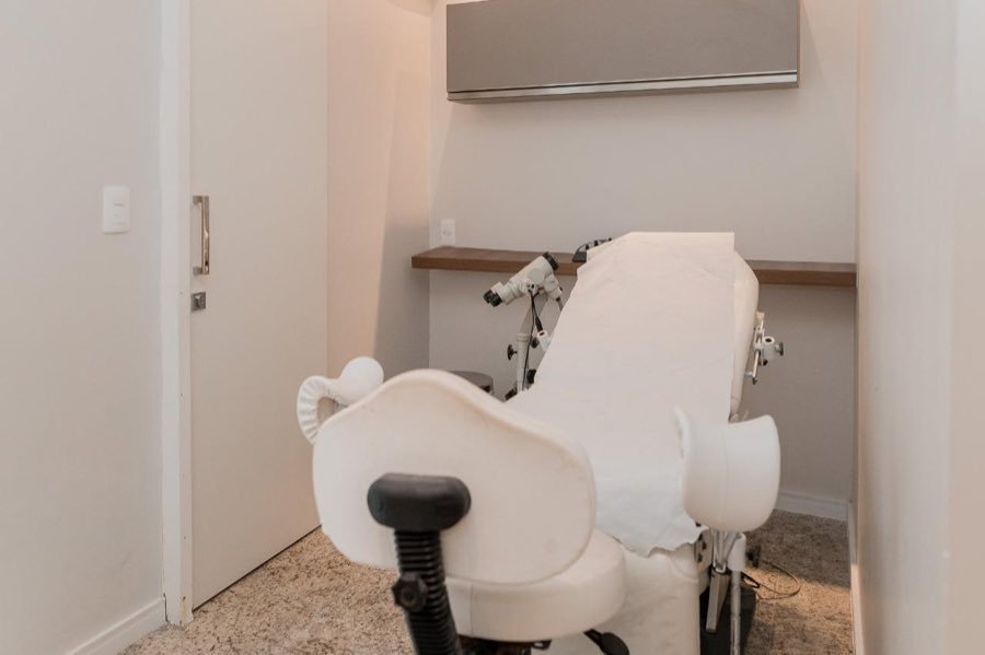 Sala de exame com cadeira ginecológica branca