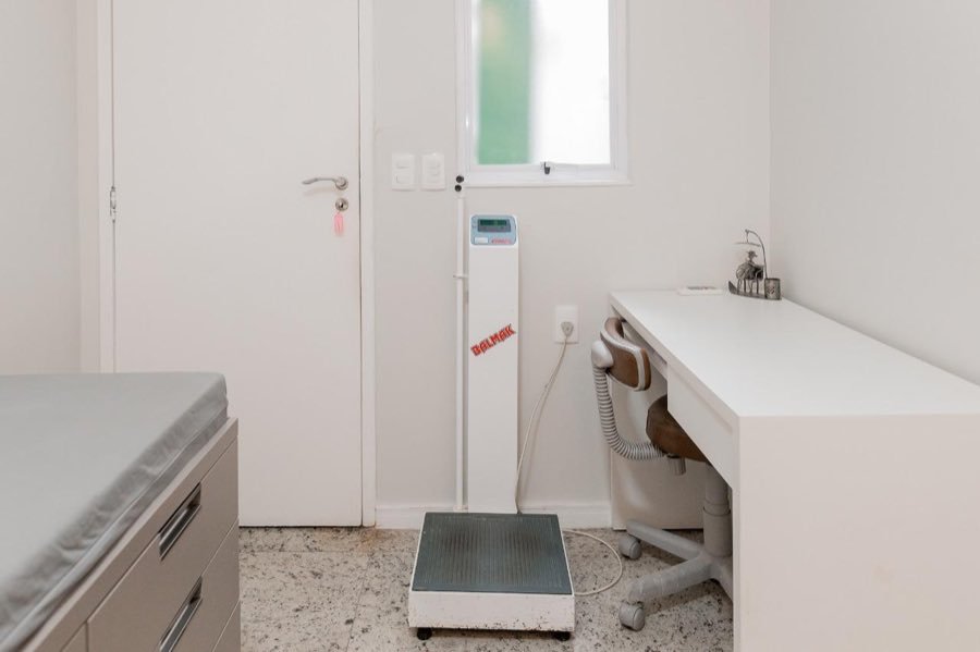 Sala com balança antropométrica e escrivaninha